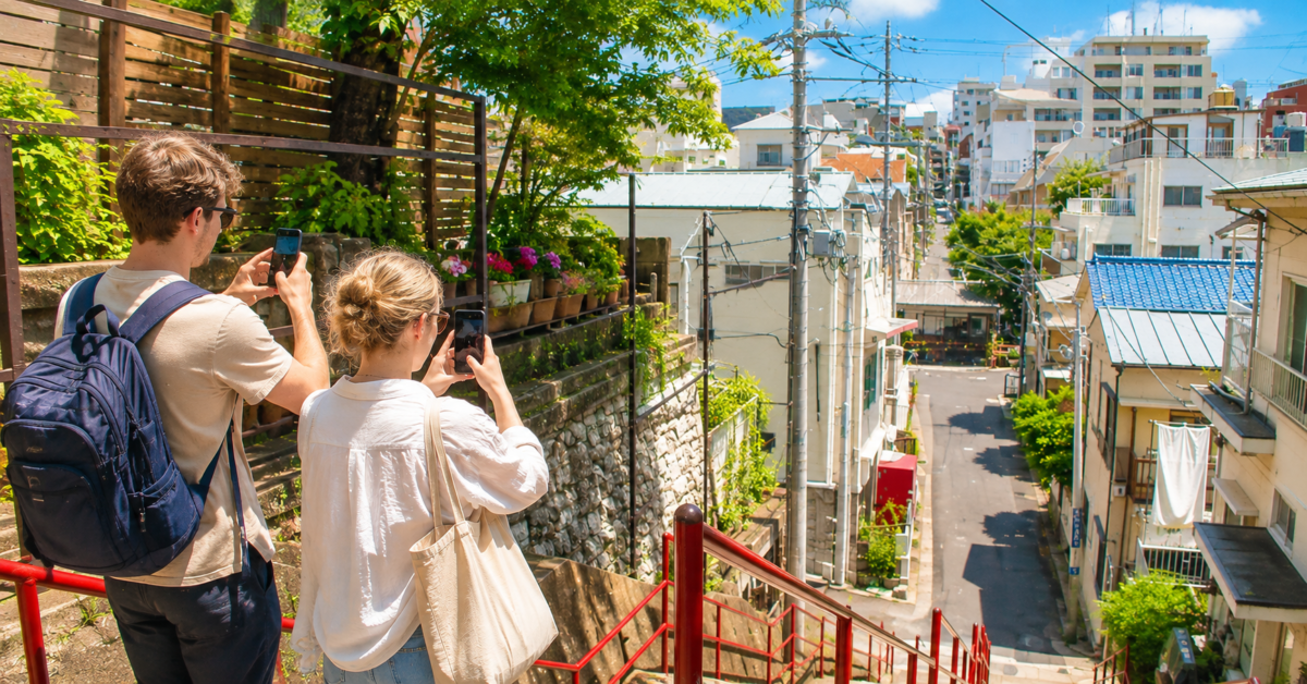 Anime fans quietly photographing an ordinary Japanese street that resembles a scene from an animated story