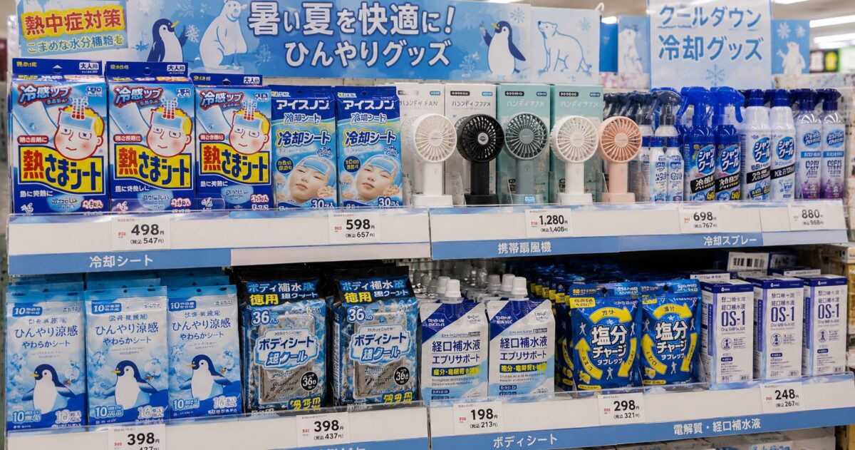 A display of cooling wipes, handheld fans, cooling sprays, and electrolyte products in a Japanese store
