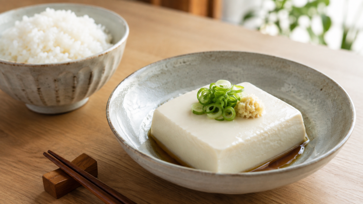 A simple Japanese tofu dish served with rice on a bright dining table